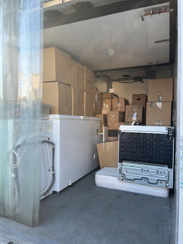 Intérieur du camion chargé de cartons et d'électroménager lors d'un débarras à Florensac