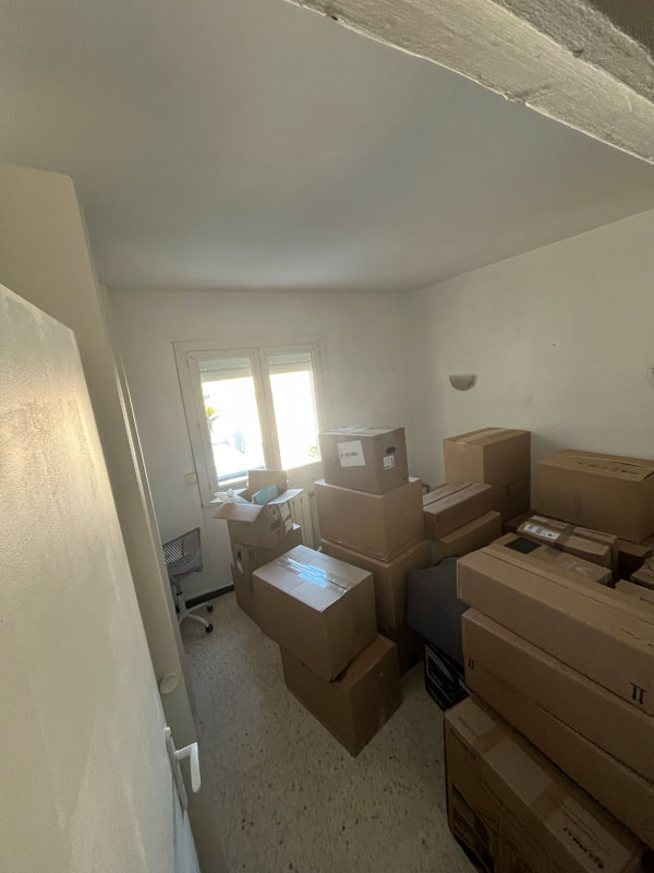 Pièce remplie de cartons prêts à être évacués lors d'un débarras à Florensac