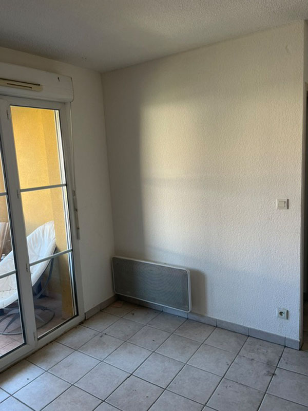 Pièce vide donnant sur un balcon après un débarras à Saint-Clément-de-Rivière