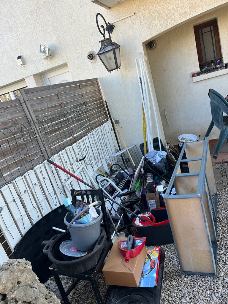 Mobilier de jardin, outillage et objets divers sortis dans la cour lors d'un débarras à Florensac