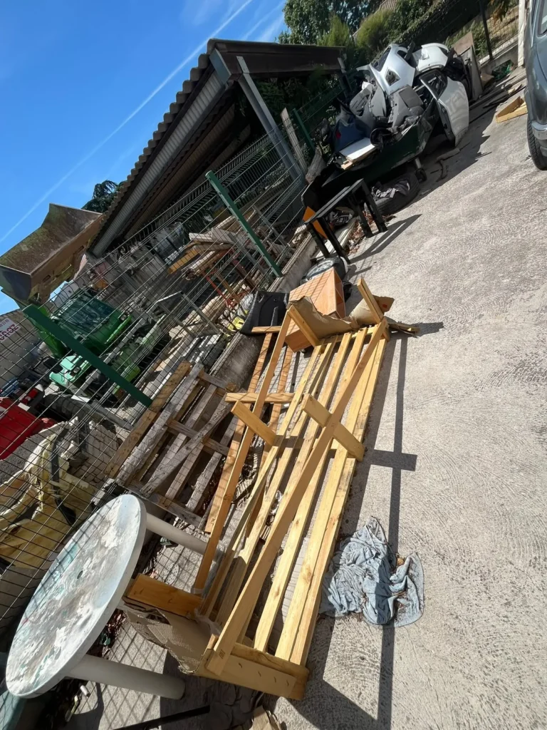 Cour encombrée de bois, de palettes et de mobilier avant enlèvement