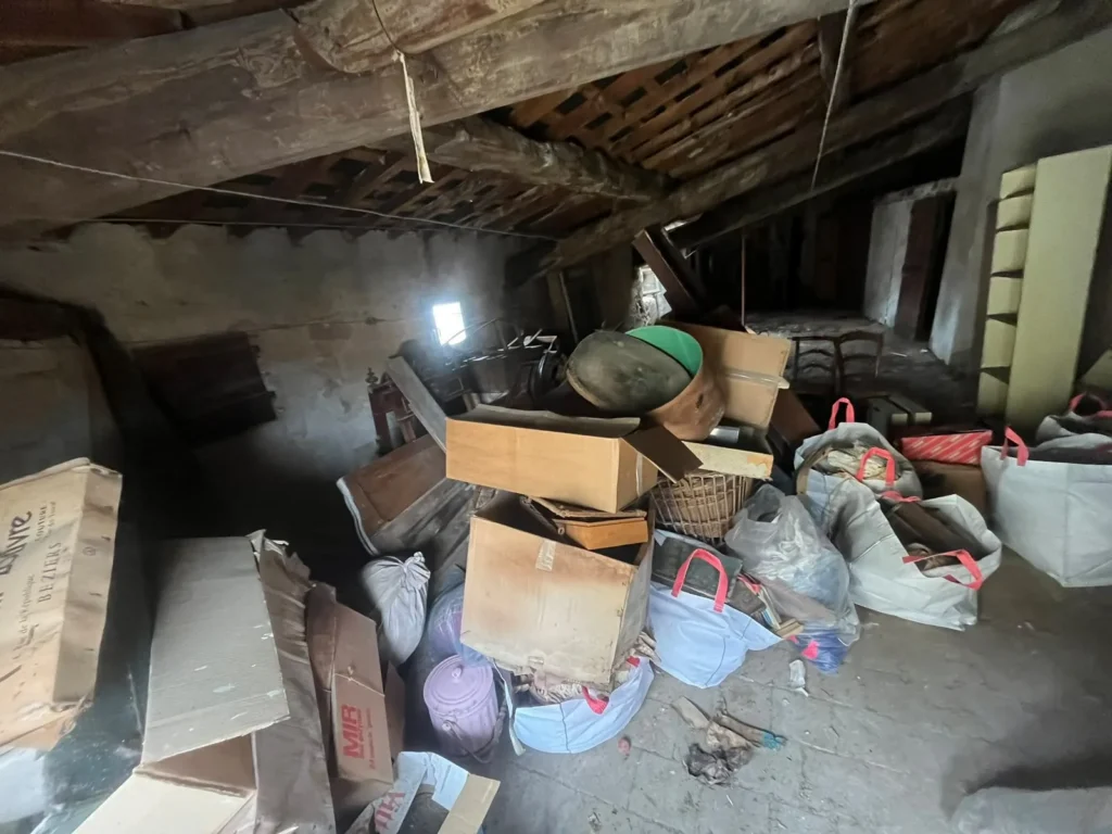 Grenier encombré de cartons et de sacs avant débarras