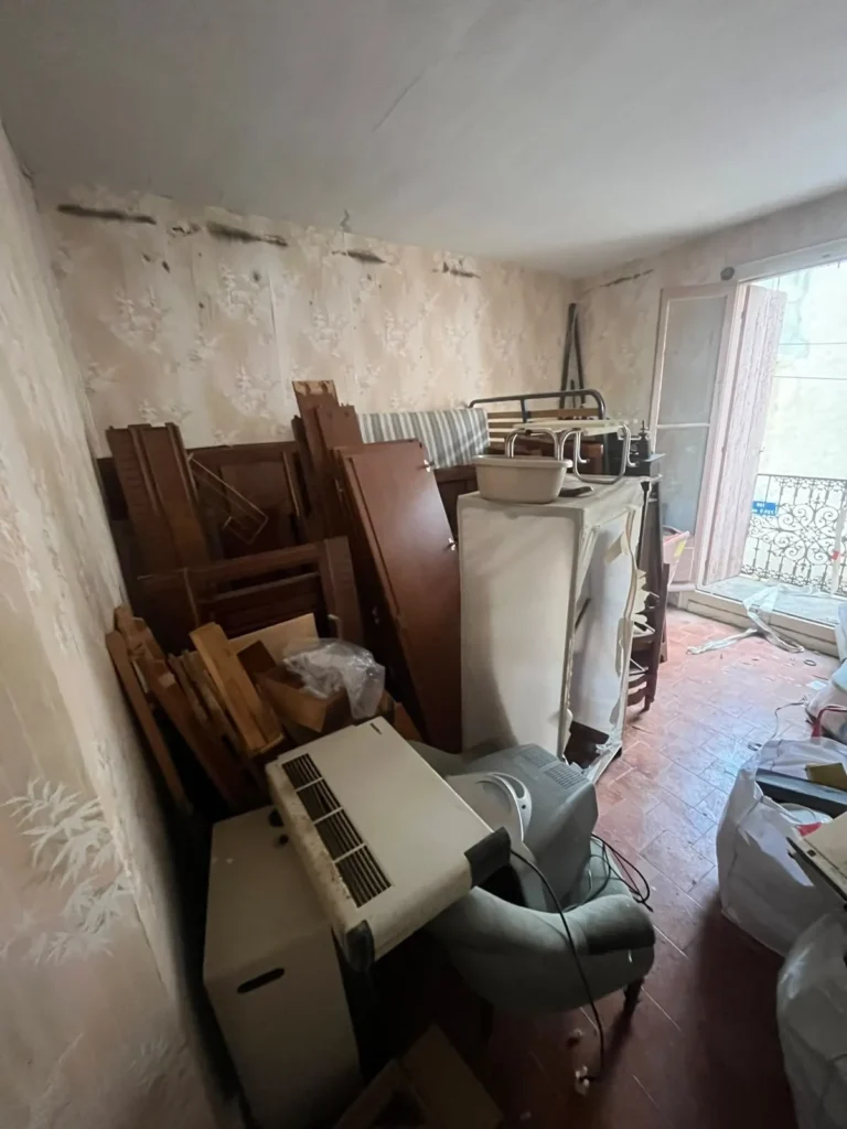 Chambre encombrée de meubles et de sacs avant débarras