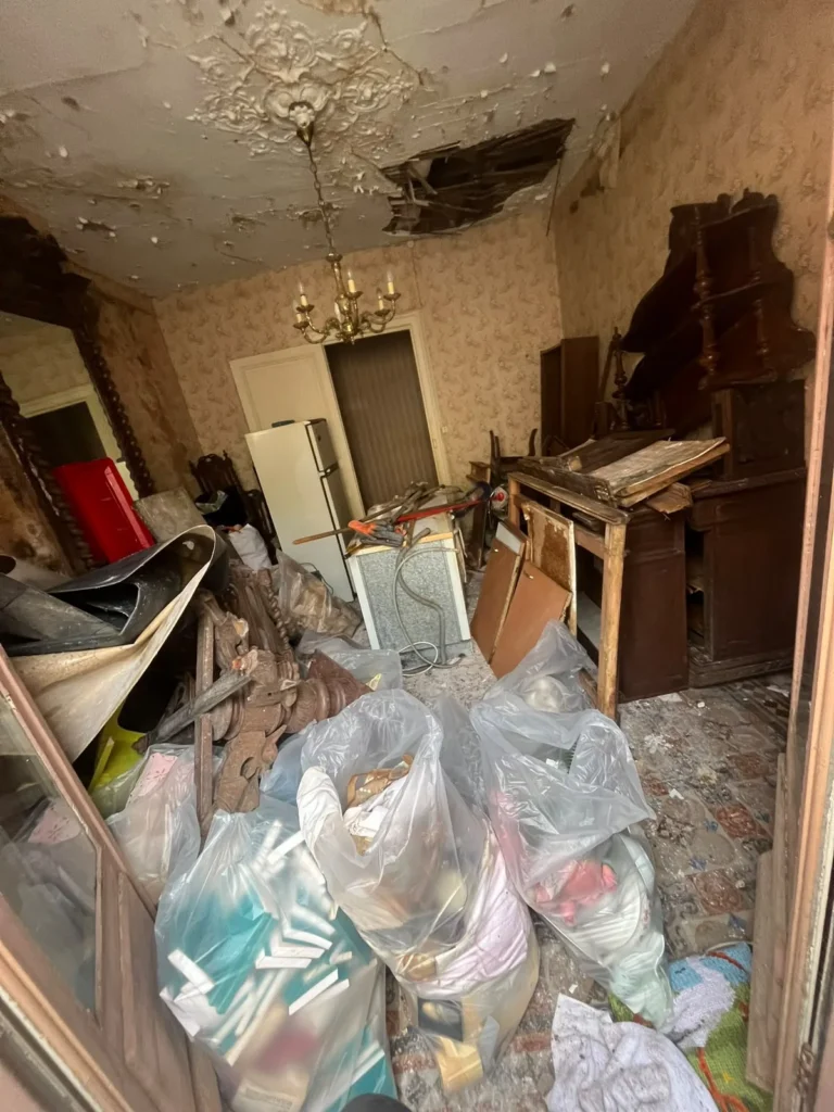 Pièce encombrée au plafond dégradé avant débarras