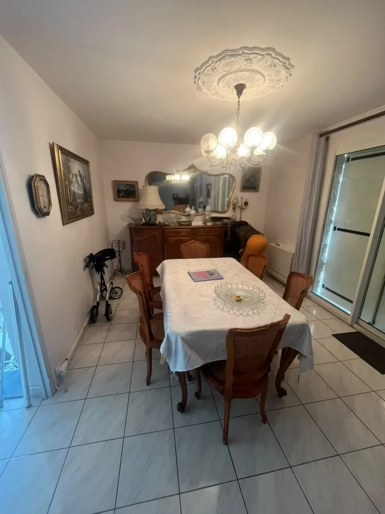 Salle à manger meublée avec buffet et lustre avant débarras