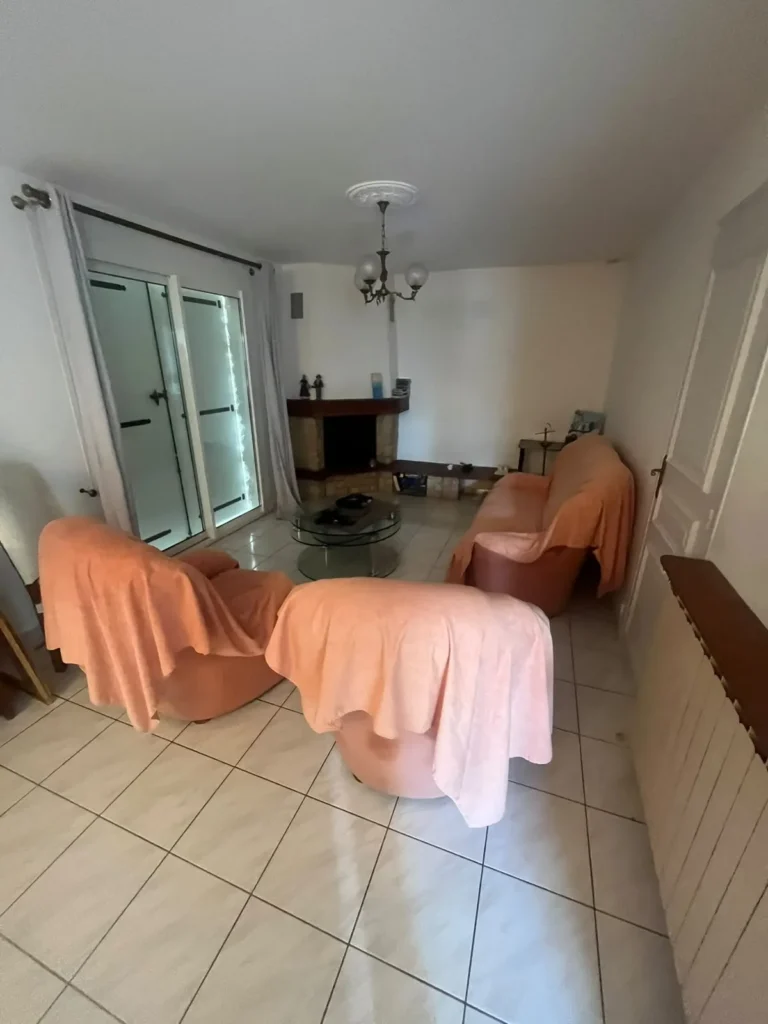 Séjour meublé de canapés et de mobilier à vider lors d'un débarras