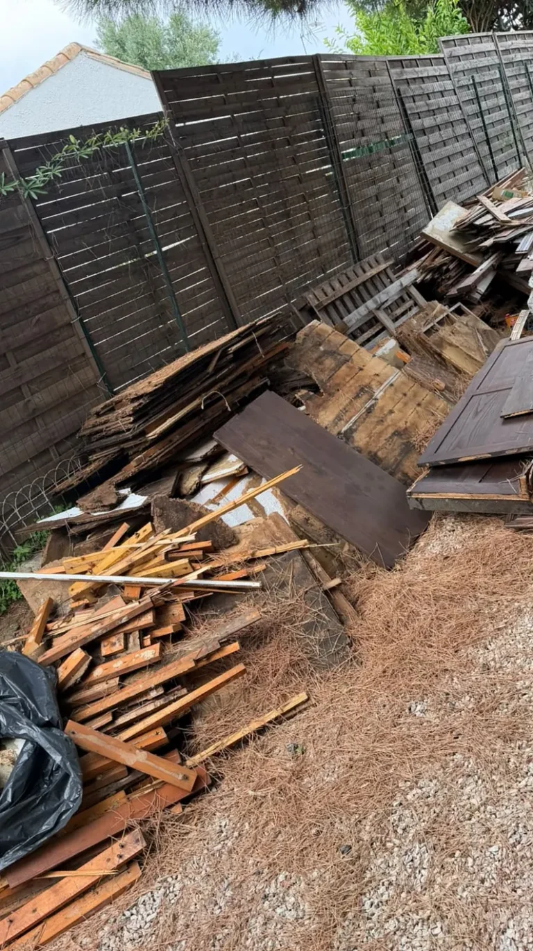 Planches et débris d'un cabanon démonté, avant évacuation, dans un jardin de Marseillan