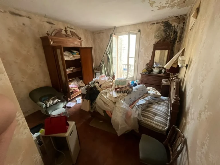 Chambre encombrée avant le débarras d'une maison insalubre à Marseillan