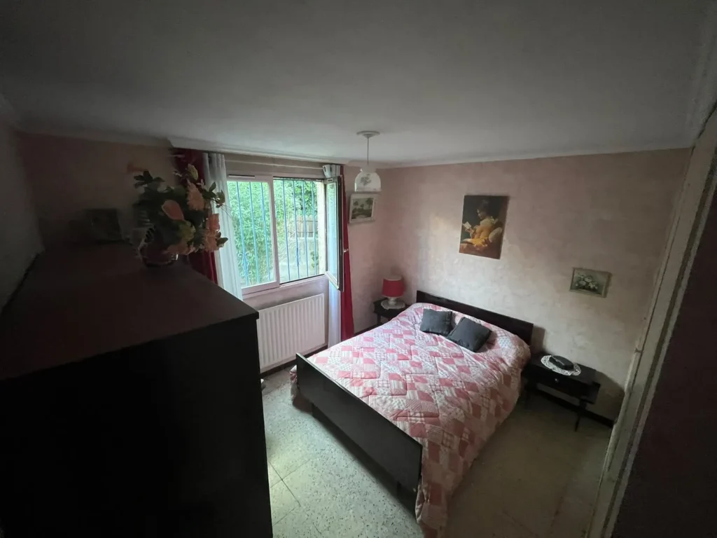 Chambre meublée avec lit et commode, avant le débarras d'une maison à Montpellier