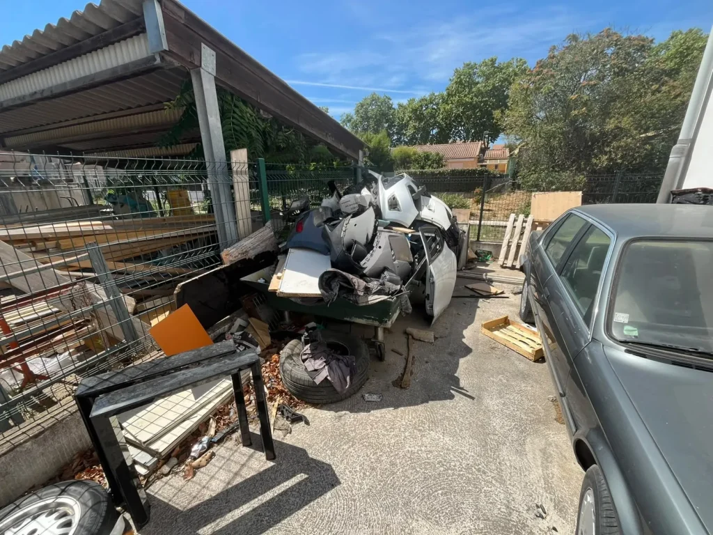 Cour et auvent encombrés avant le débarras d'une carrosserie à Pézenas