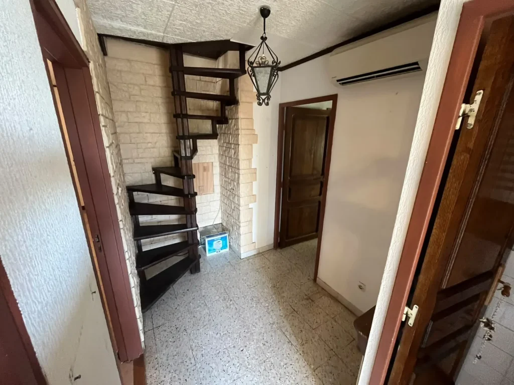 Entrée et escalier en colimaçon dégagés après le débarras d'une maison aux Hauts de Massane, à Montpellier