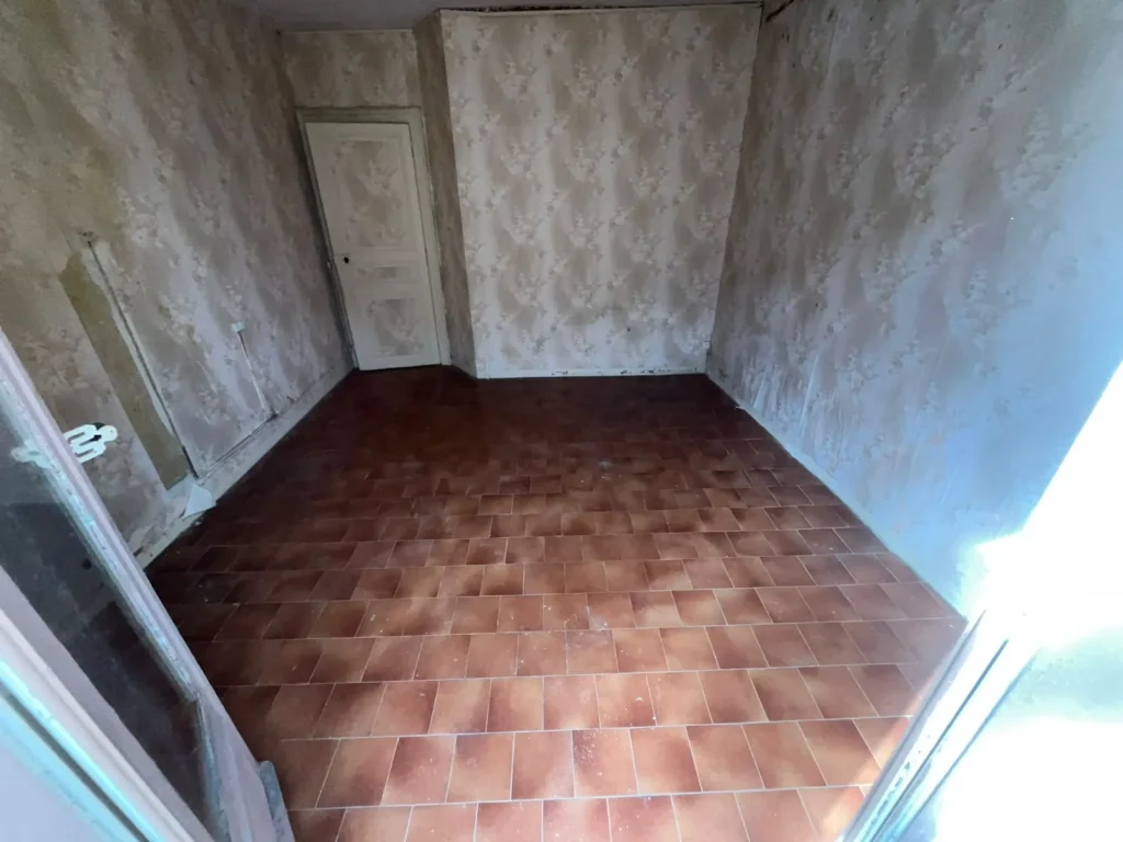 Pièce aux tomettes vidée après le débarras d'une maison ancienne à Marseillan