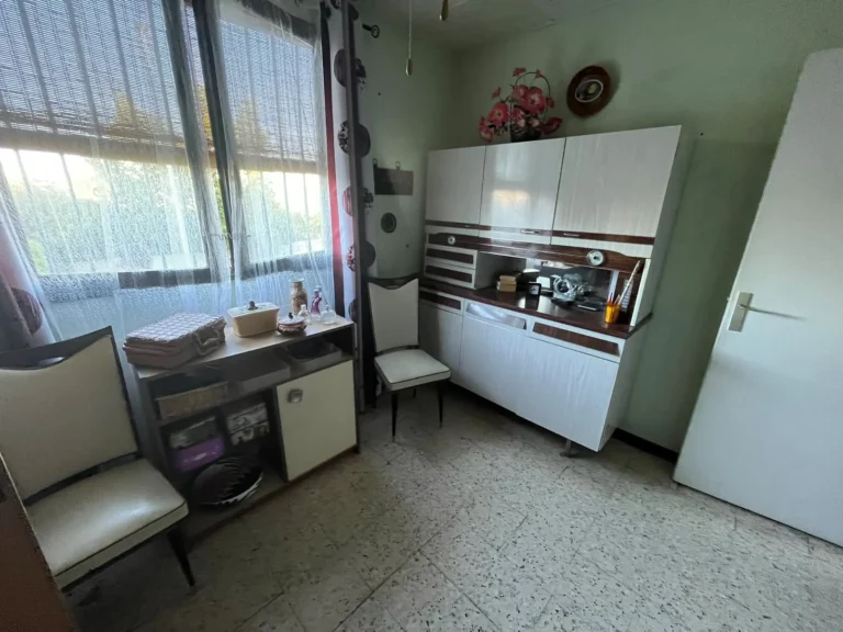 Pièce avec buffet de cuisine et chaises avant le débarras, aux Hauts de Massane à Montpellier